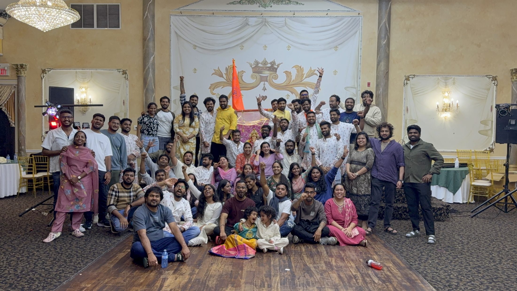 SSVCA members and volunteers cheering together in front of the Ganesha altar